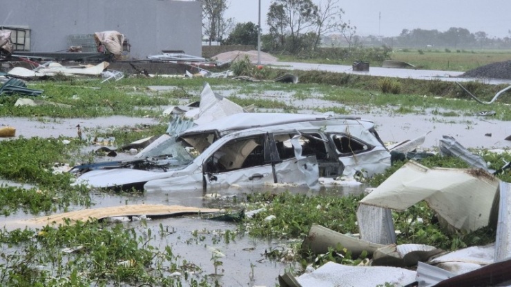 Chiếc xe ô tô nhãn hiệu Toyota Veloz bị gió cuốn 300m, bẹp rúm dưới ruộng rau muống.