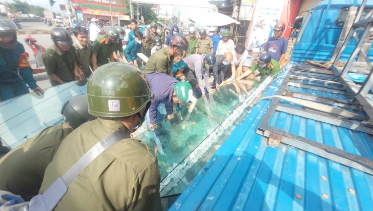 Lực lượng chức năng xã Bình Đức (Tây Ninh) cùng người dân giải cứu hai công nhân bị hàng chục tấm kính cường lực đổ đè lên người.