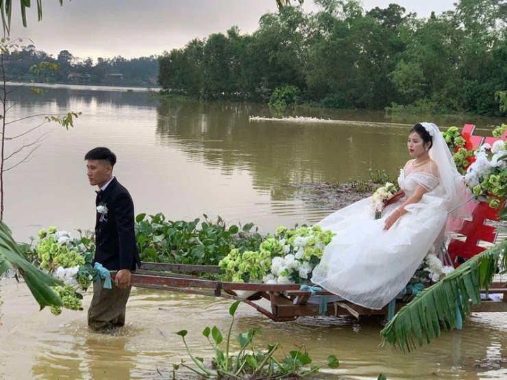 Chú rể không thể đi lối tắt nên tự kéo xe đưa cô dâu qua đoạn đường ngập 