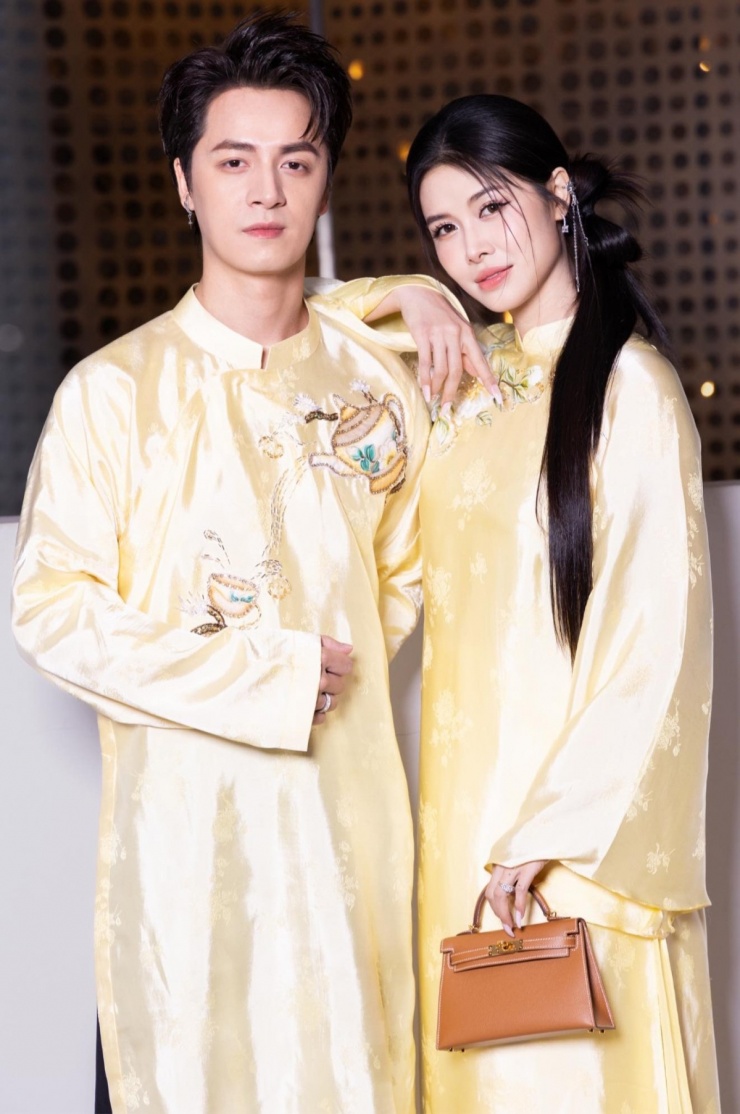 Xuất hiện trong một sự kiện thời trang hôm 2/10 tại TP HCM, cặp sao ghi điểm với bộ áo dài lụa vàng mơ thêu họa tiết hoài cổ. Thủy Anh xách túi Kelly tạo điểm nhấn sang trọng cho bộ đồ truyền thống.