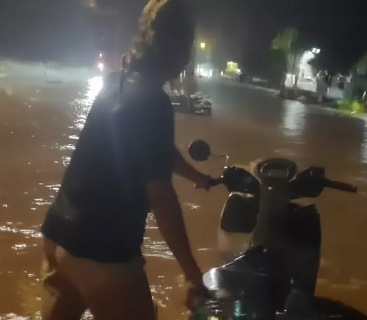 Nhiều người dân phải dắt xe máy di chuyển qua điểm ngập lụt trên quốc lộ. Ảnh: N.D