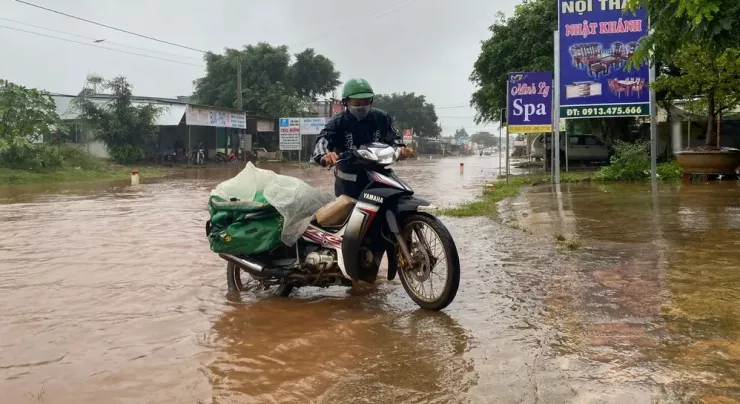 Một xe chết máy vì quốc lộ 27 ngập, người dân phải dắt bộ. Ảnh tư liệu.