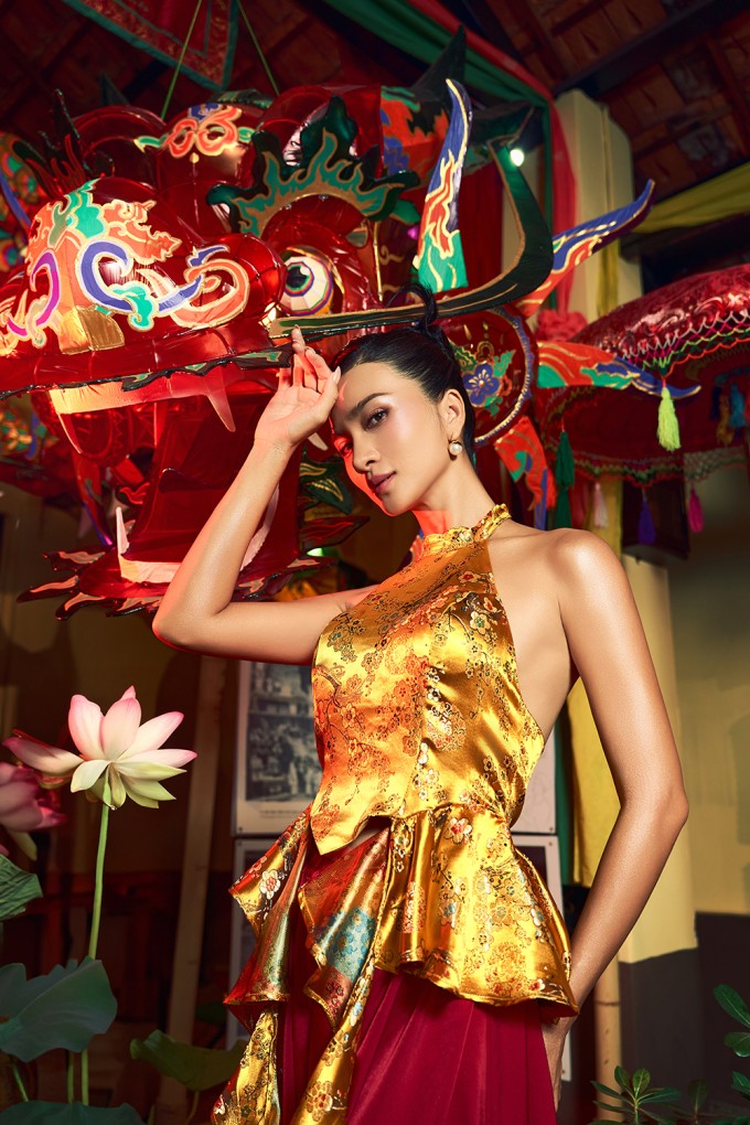 Đường chiết eo ôm khít vòng hai kết hợp xẻ tà tạo nên sự cách điệu trẻ trung so với áo yếm truyền thống. Trong khi đó, chất liệu gấm gợi vẻ sang trọng.