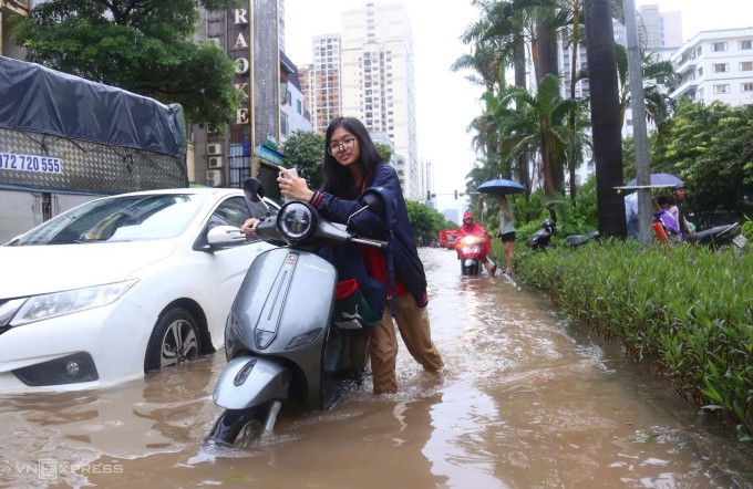 Học sinh dắt xe qua đoạn ngập trên phố Hàm Nghi, ngày 30/9. Ảnh: Phạm Dự