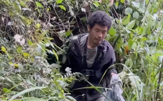 Hình ảnh Yang đang tìm kiếm thức ăn trong rừng khi tham gia thử thách. Ảnh: SCMP