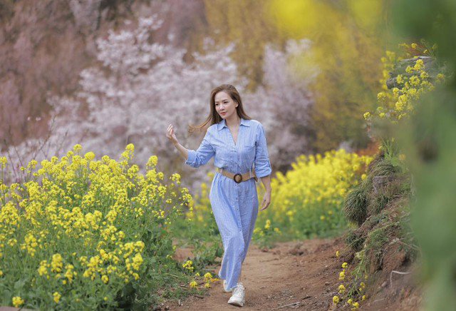 Khi đi chơi trên núi, cô diện váy liền thân màu xanh pastel mix cùng giày sneaker. Điểm nhấn của trang phục chính là chiếc đai lưng tinh tế.