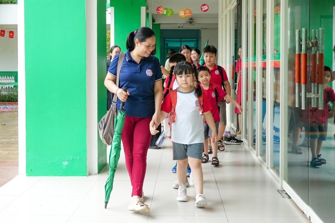 Học sinh trường Tiểu học Lê Quý Đôn, phường Mỹ Đình 1, rời trường sáng 1/10 sau một đêm ngủ lại vì mưa lớn gây ngập. Ảnh: Fanpage nhà trường
