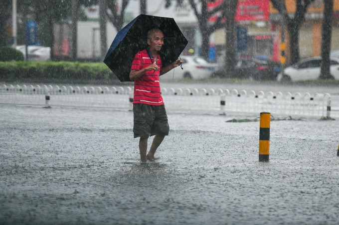 Người dân di chuyển trên đường ngập ở Hải Khẩu, Hải Nam ngày 5/10. Ảnh: VCG