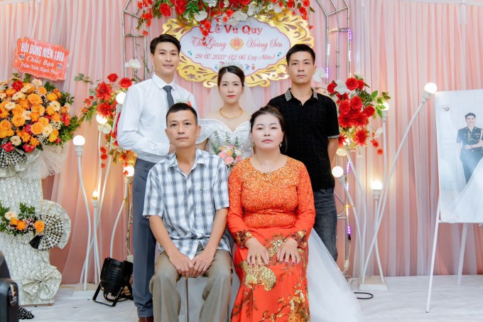 Anh Tấn, chị Thêm và con trai (áo đen) chụp ảnh lưu niệm trong đám cưới Giang, năm 2023. Ảnh gia đình cung cấp