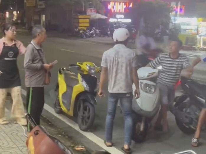 Người đàn ông quay xe đuổi theo đòi hành hung ông cụ bán vé số (ảnh cắt từ clip)