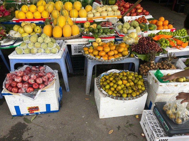 Để tránh ngập nước, chị Liên kê sạp hàng lên cao bằng thùng xốp. Ảnh: Đan Tâm.