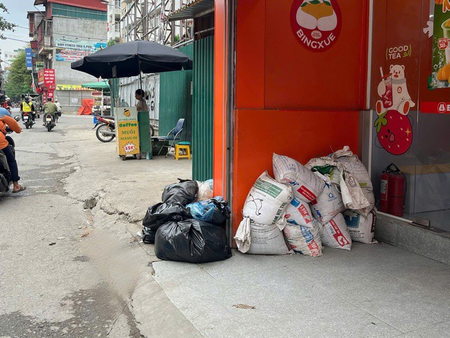 Một số gia đình chủ động để sẵn bao cát trước cửa nhà, đề phòng nước tràn vào khi mưa lớn. Ảnh: Đan Tâm.