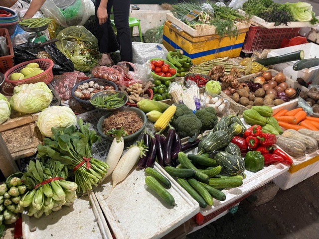 Tiểu thương bán rau hạn chế nhập hàng vì lo ngại mưa lớn, ngập chợ khiến rau hư hỏng. Ảnh: Đan Tâm.