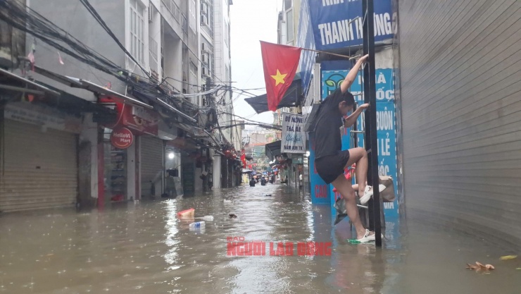 Mưa ngập tràn vào nhà, người dân làng bún Phú Đô (Hà Nội) phải trèo thang thoát hiểm ra ngoài để đảm bảo an toàn. Ảnh: Văn Duẩn