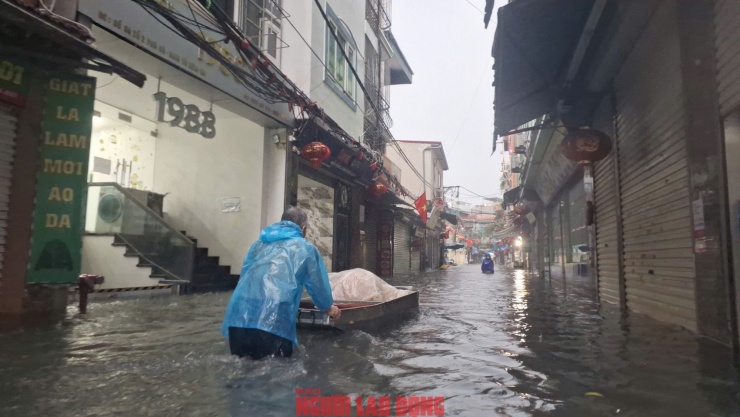 Người dân đã phải dùng xuồng để di chuyển đồ đạc trong sáng sớm 7-10. Ảnh: Văn Duẩn