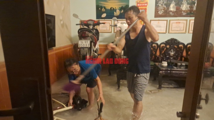 Nước ngập tràn vào nhà, người dân phải khiêng các vật dụng có giá trị lên cao để tránh thiệt hại. Ảnh: Văn Duẩn