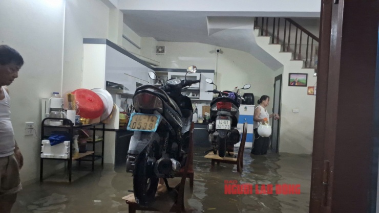 Nước ngập tràn vào nhà, người dân phải khiêng tủ lạnh, xe máy và các vật dụng có giá trị lên cao để tránh thiệt hại. Ảnh: Văn Duẩn