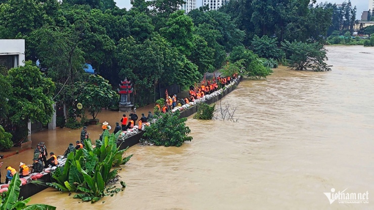 Lực lượng chức năng gia cố đê sông Cầu (phường Phan Đình Phùng).