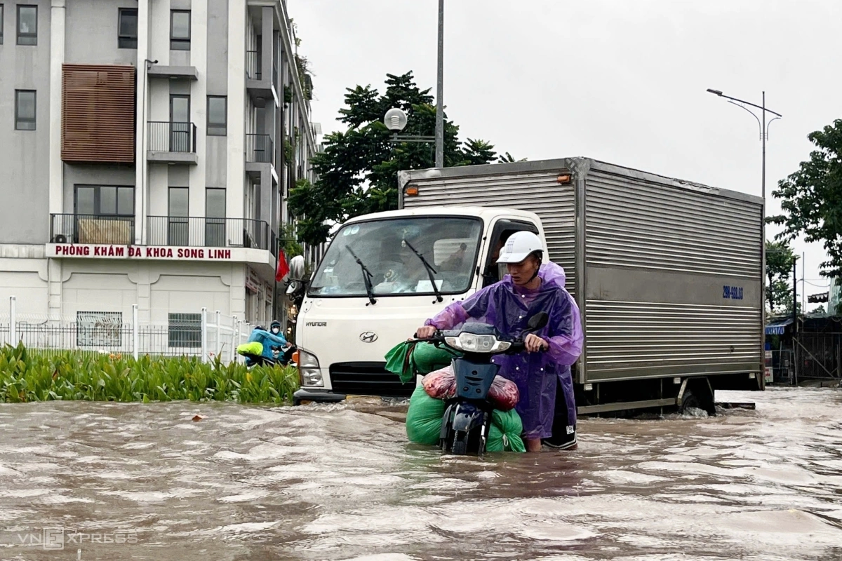 Người dân vất vả đi qua khu vực ngập nước. Ảnh: Huy Mạnh