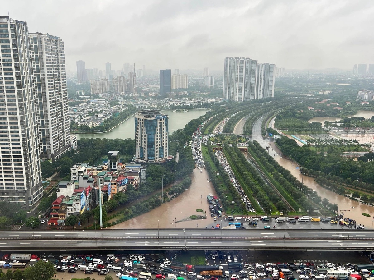 Các phương tiện nép hàng dài sát đường trên cao để tránh đường ngập phía dưới. Ảnh: Giang Trịnh