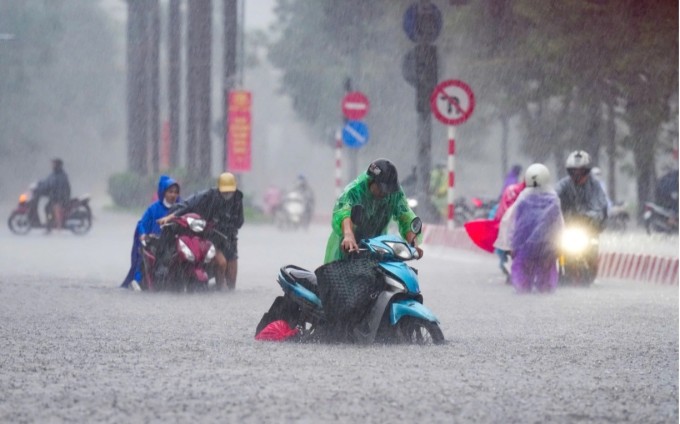 Trên phố Nguyễn Hoàng, nhiều phải dắt xe lội bộ dưới mưa to, nước dâng cao khoảng 0,4 m. Ảnh:Tùng Đinh