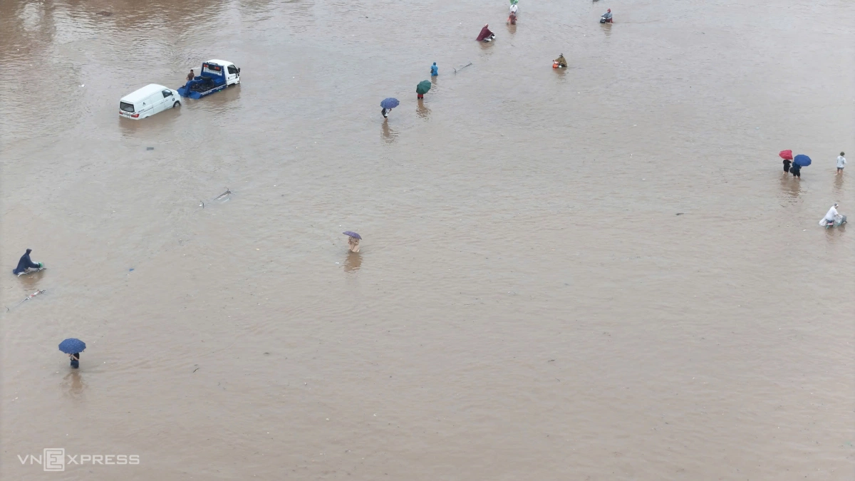 Người dân mò mẫm đi trong biển nước trước sân vận động Mỹ Đình. Ảnh: Văn Ngọc