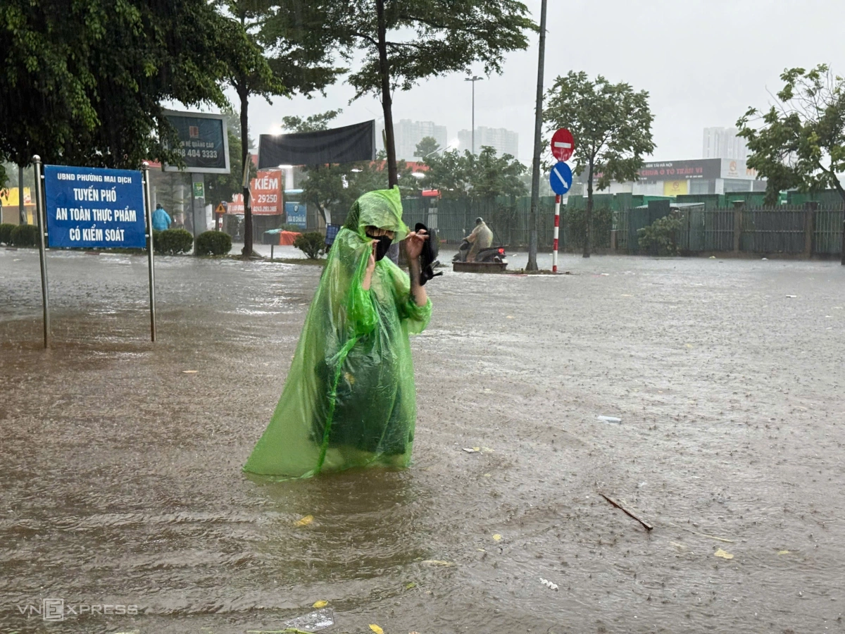 Người dân đi lại khó khăn trong dòng nước ngập. Ảnh: Lộc Chung
