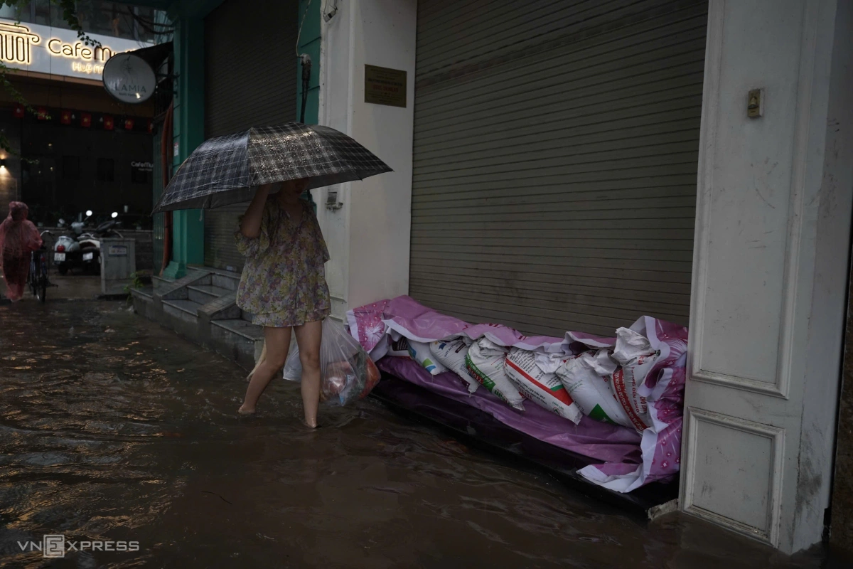 Trên phố Giang Văn Minh, mực nước ngập khoảng 50 cm, các hộ dân phải chặn bao cát để ngăn nước tràn vào. Ảnh: Hoàng Giang