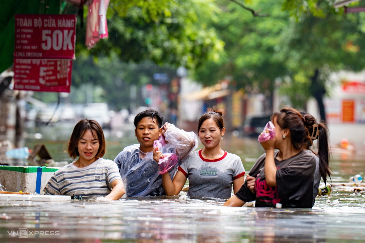 Nước cao quá bụng người trên phố Phan Văn Trường, nhiều tuyến phố tê liệt do ngập sâu. Ảnh: Tùng Đinh