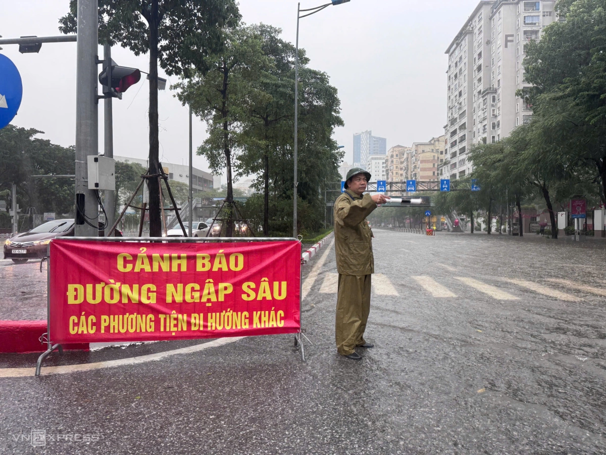 Lực lượng chức năng hạn chế phương tiện đi vào đường Võ Chí Công do đã ngập sâu. Ảnh: Anh Phú