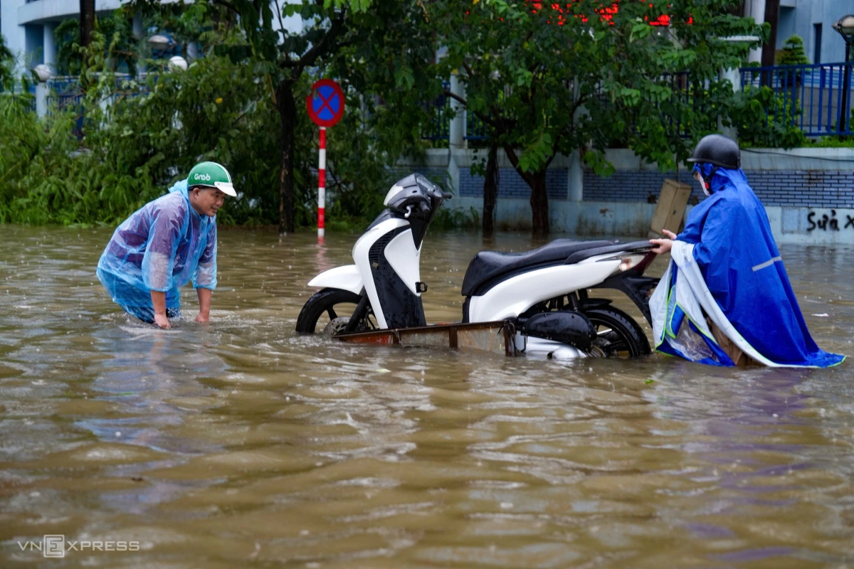 Người dân phải dùng xe kéo đưa xe máy ra khỏi điểm ngập gần bến xe Mỹ Đình. Ảnh Đinh Tùng