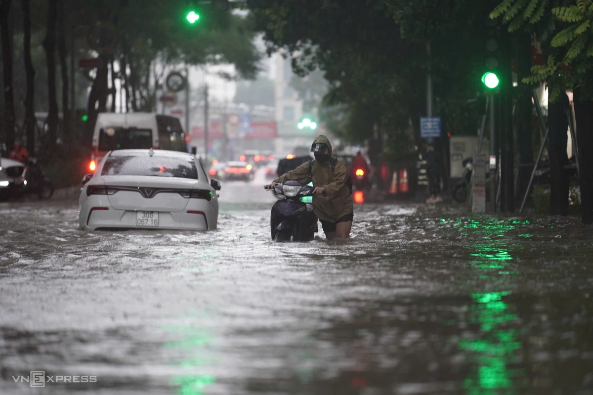 Hầu hết người đi xe máy phải dắt bộ qua những đoạn đường mênh mông nước. Ảnh: Hoàng Giang