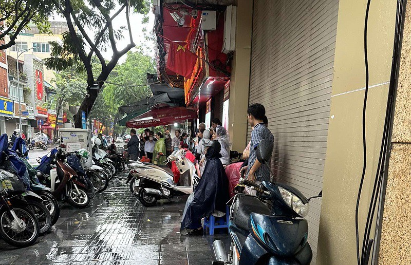 Nhiều người đội mưa đi xếp hàng mua vàng ngày 7/10. (Ảnh: Tiến Phạm)