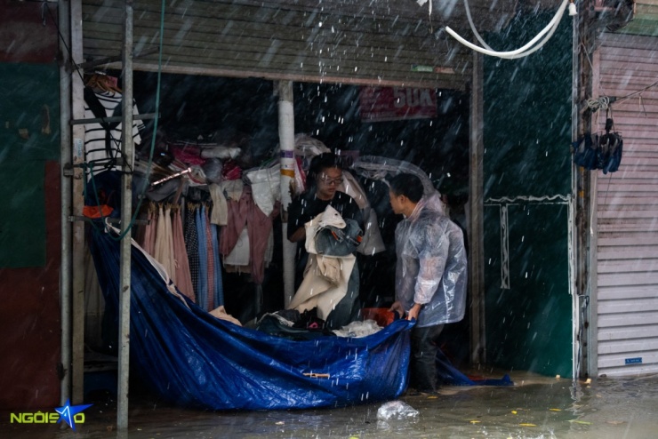 Trong ảnh, hàng chục ki-ốt tại chợ Nhà Xanh chìm trong biển nước. Nhiều tiểu thương nhận được tin vội vàng từ nhà chạy ra, hô hoán nhau cùng dọn hàng tránh thiệt hại.