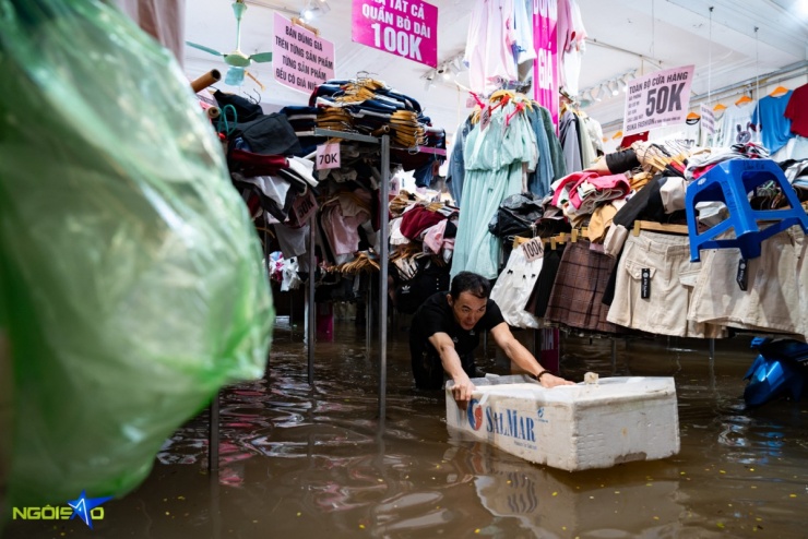 Anh Giàng Mí Phú (28 tuổi) liên tục di chuyển quần áo ướt ra khỏi khu vực ngập, ước tính tổng thiệt hại lên tới khoảng 50 triệu đồng.