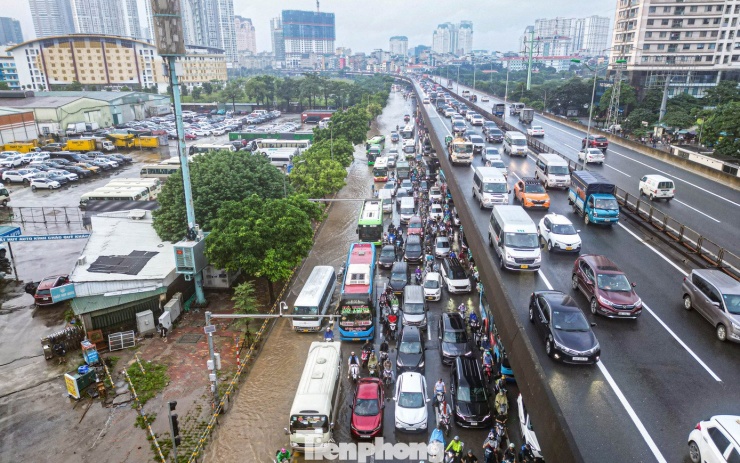 Xe máy ‘rẽ sóng’ giữa phố, tìm đường lên cao tốc tránh ngập tại Hà Nội - 2