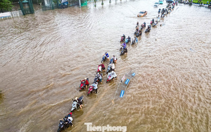 Xe máy ‘rẽ sóng’ giữa phố, tìm đường lên cao tốc tránh ngập tại Hà Nội - 13