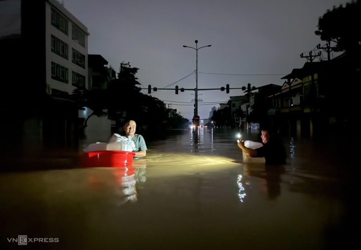 Người dân Thái Nguyên mò mẫm trong nước lụt di tản đồ đạc hoặc lấy nước sạch về dùng.