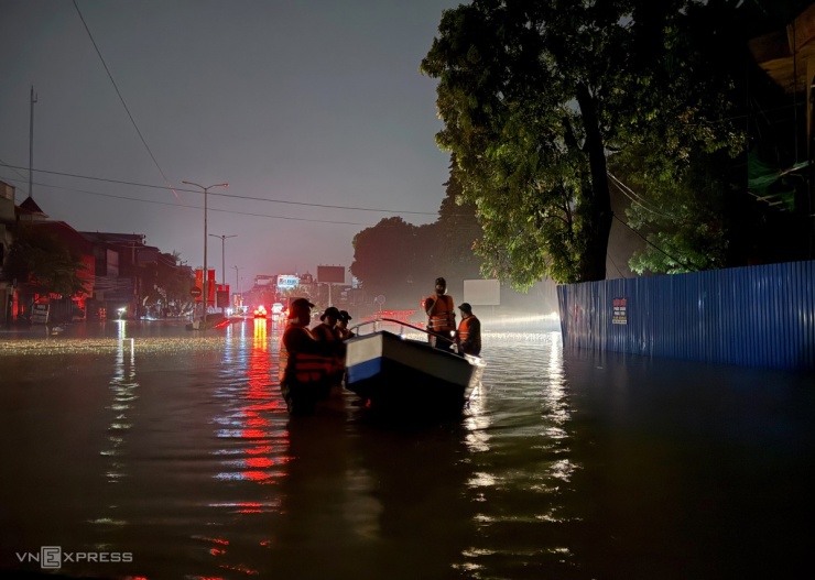 Trong đêm, lực lượng chức năng dùng xuồng cứu hộ tiếp cận các khu dân cư ngập sâu để hỗ trợ sơ tán dân.