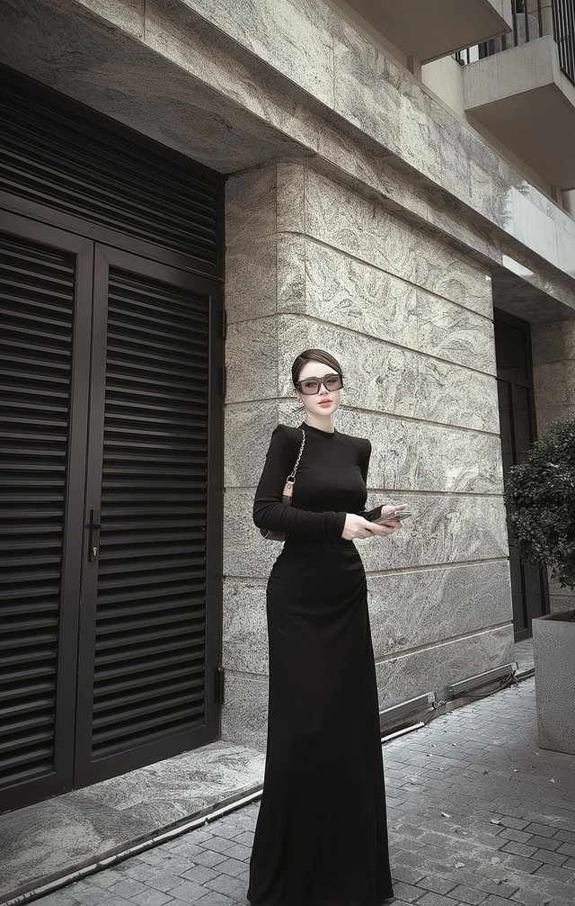 Ở set đồ váy liền thân dài, Lương Thu Trang tạo điểm nhấn khi mix mắt kính và túi sành điệu.