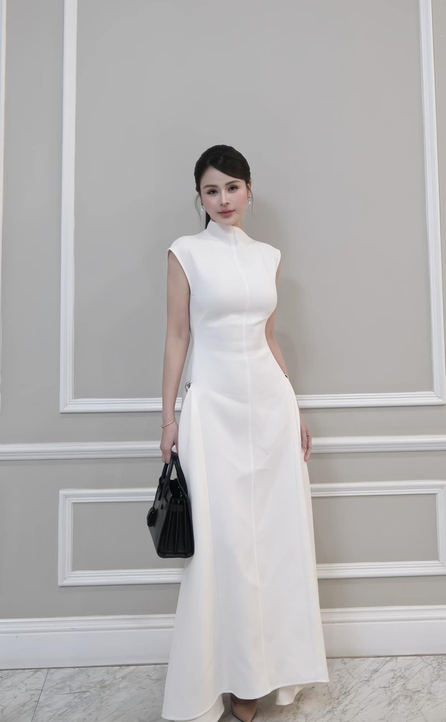 Hoặc với set đầm màu trắng, người đẹp "Dịu dàng màu nắng" lại nổi bật nữ tính khi mix đồ cùng hoa tai ngọc trai và chiếc túi xách màu đen tạo điểm nhấn.