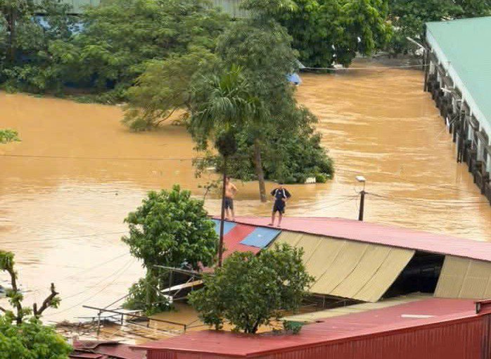 Người dân trèo lên nóc nhà khi nước lũ dâng cao. Nguồn: MXH