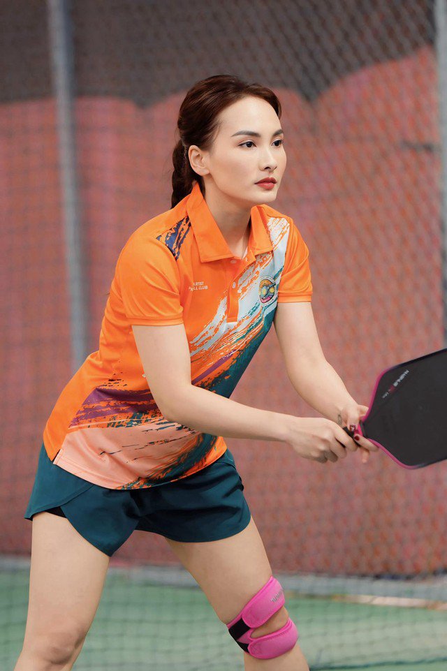 Có lúc cô giản dị với bộ trang phục chơi thể thao thoải mái với áo dáng polo cam và quần gọn gàng.