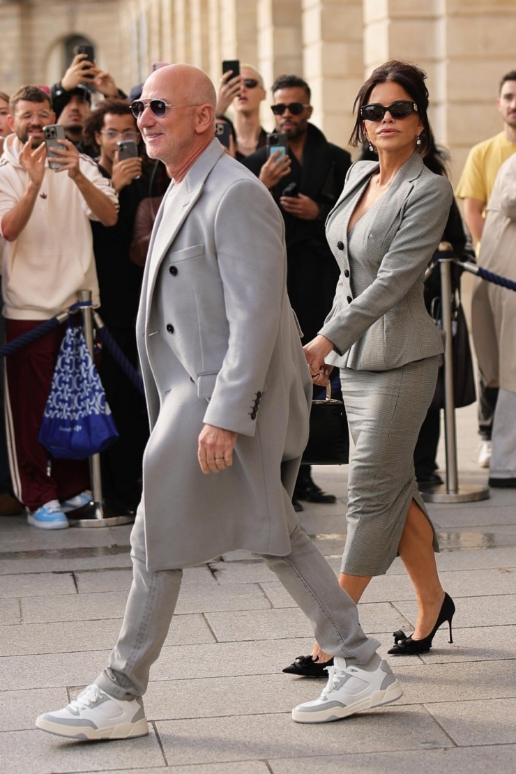 Trước đó một ngày, vợ chồng tỷ phú Jeff Bezos xuất hiện trên đường phố Paris trong hai bộ đồ màu xám. Sanchez diện áo peplum và váy suit vintage của John Galliano thuộc bộ sưu tập Xuân Hè 1995. Nhà sáng lập Amazon mặc tông xuyệt tông với vợ. Ảnh: Backgrid