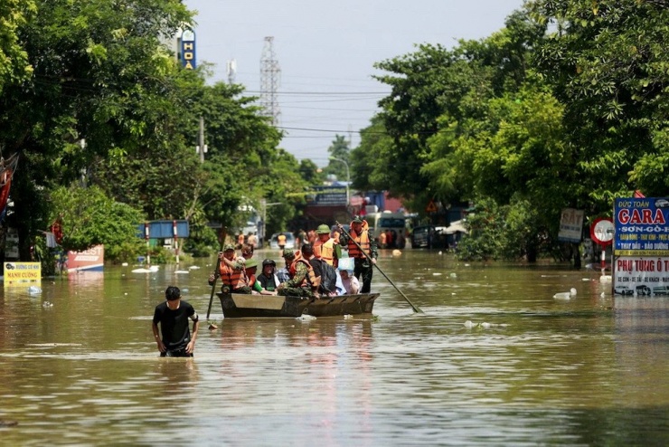 Lực lượng cứu hộ đưa người dân đến khu vực an toàn. Ảnh: Phạm Hải