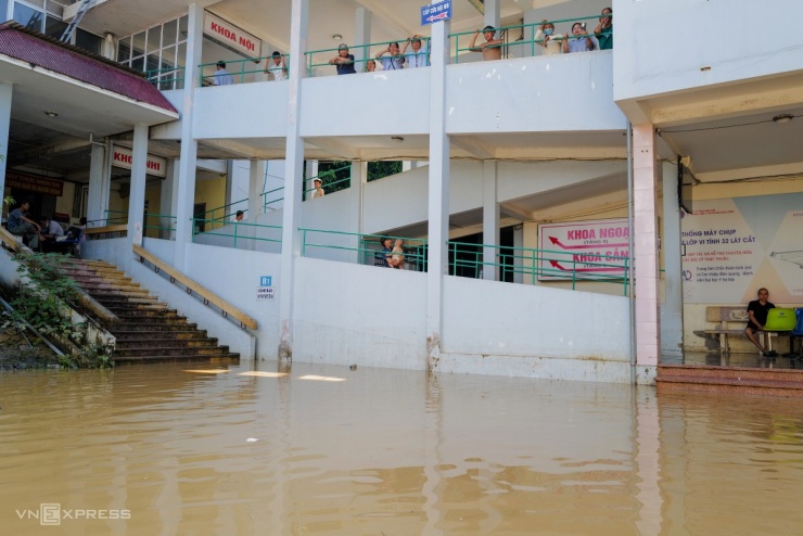 Khoảng sân trong bệnh viện lênh láng nước. Gần 300 bệnh nhân đã được di dời lên tầng hai để tránh trú.
