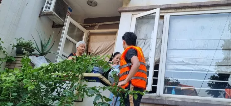 Bà Đào Thị Hương, 80 tuổi và bà Đào Thị Hải, 85 tuổi nhận nước và mỳ tôm. Bà Hương nói may quá cả ngày hôm nay mới có người hỗ trợ "giờ thì sống rồi".