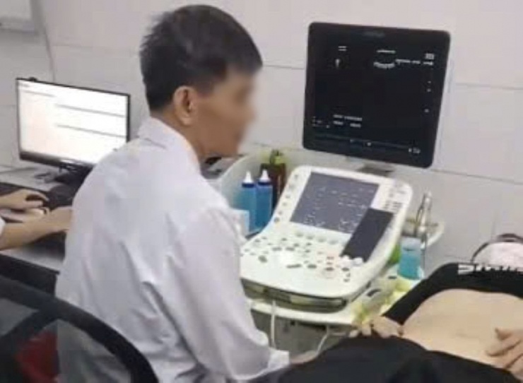 Hình ảnh bác sĩ được cho là vừa siêu âm vừa xem điện thoại. Ảnh cắt từ clip