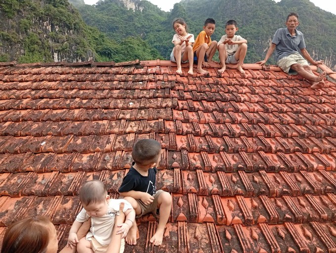 5 đứa trẻ, là con của Liên và hàng xóm trèo lên nóc nhà gọi cứu trợ, sáng 8/10. Ảnh nhân vật cung cấp