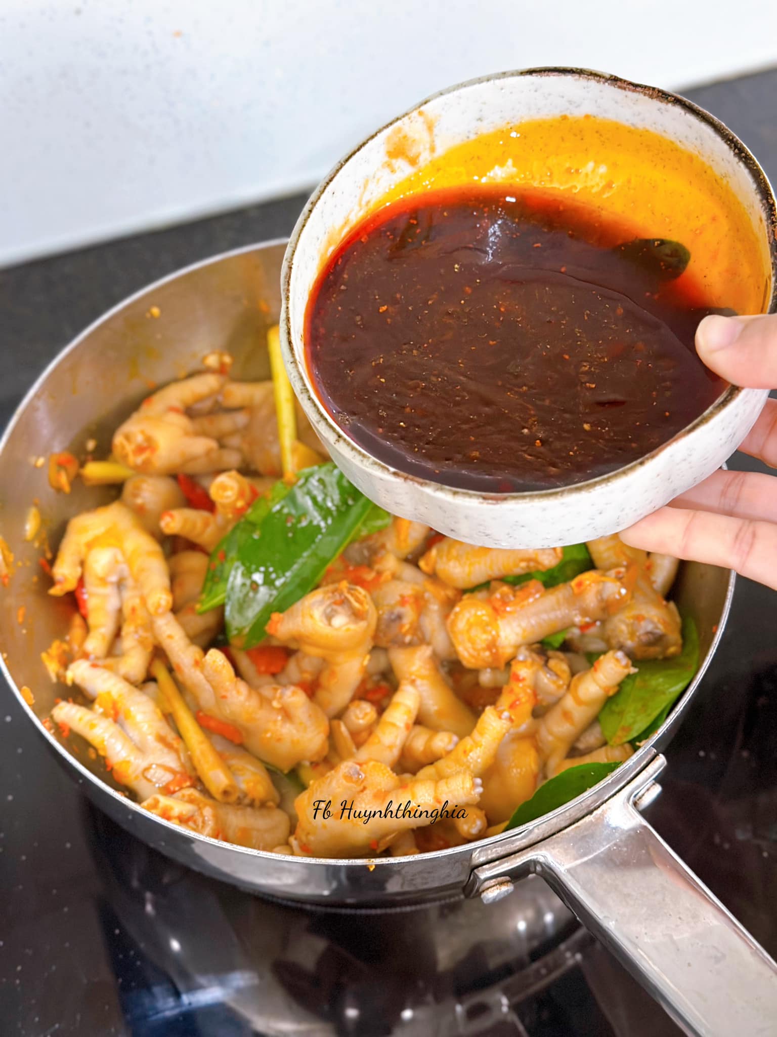 Cho dầu điều vào chảo, phi thơm&nbsp;hành tím và tỏi, tiếp đến cho ớt sừng&nbsp;xay nhuyễn, ớt cay, lá chanh và chân gà vào đảo đều. Tiếp tục cho nước xốt đã chuẩn bị và 2 chén nước lọc xào đến khi chân gà thấm và mềm, nước xốt sệt lại thì tắt bếp.